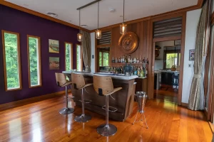 Photo of stylish home bar with three wooden stools by Cape Cod real estate photographer Daniel Baci