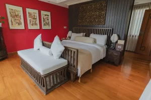 Photo of a bedroom with a wooden bed and bench by Cape Cod real estate photographer Daniel Baci.