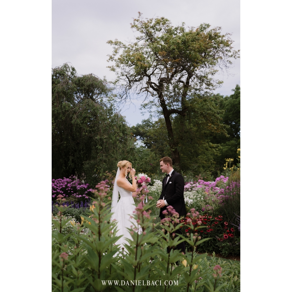 Bride crying as groom reads a private message to her during their first look in the gardens of Glen Magna Farms wedding venue in Massachusetts.