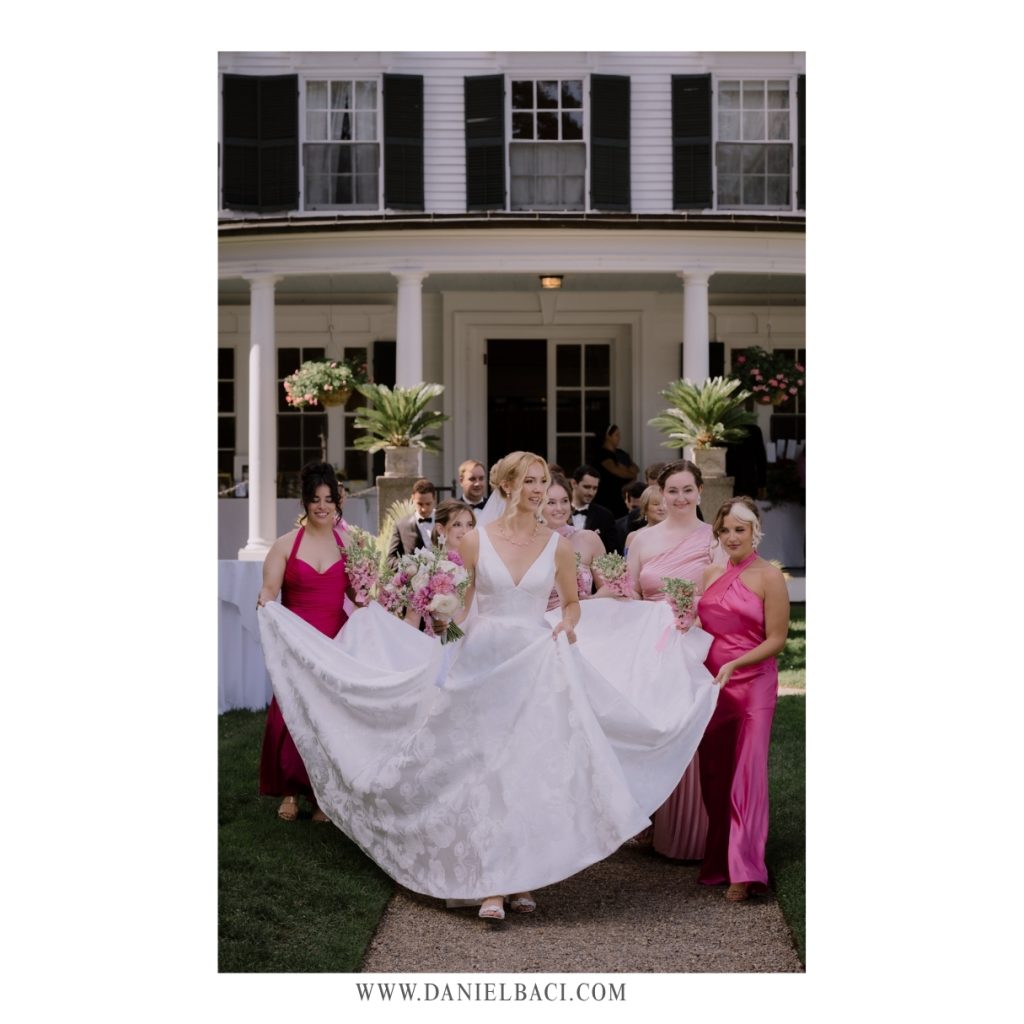 Bridal party helping bride carry her dress at luxury wedding venue in the North Shore, MA..