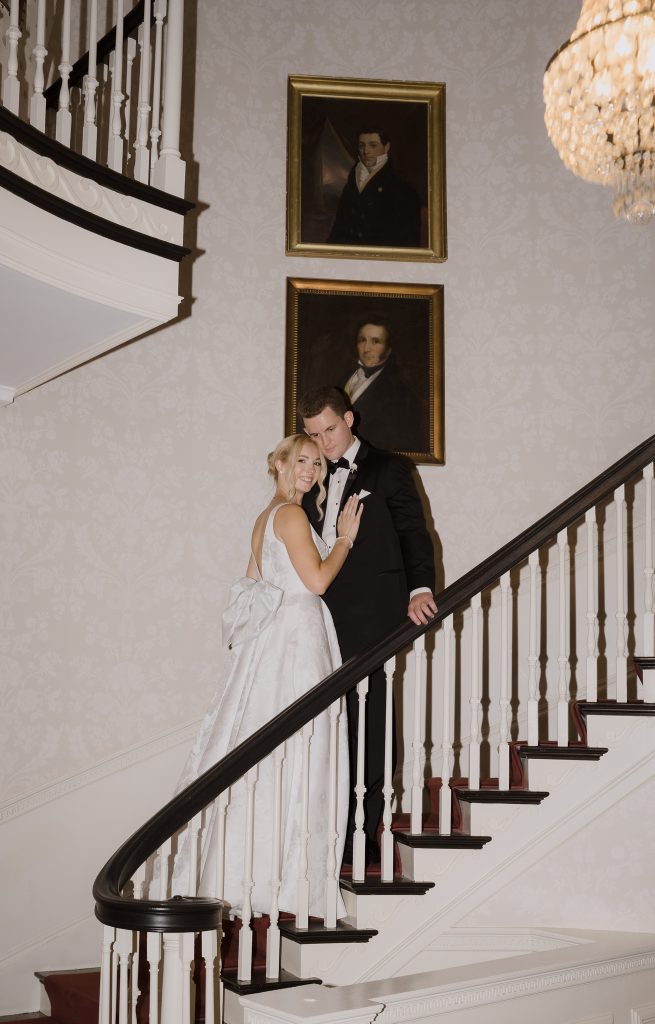 Bride and groom pose on a grand staircase