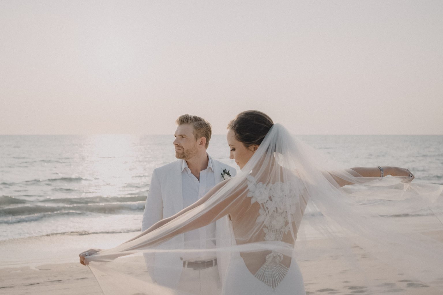 Soft portrait of bride and groom during the golden hour on the beach in Cape Cod, beautifully captured by Daniel Baci Photography